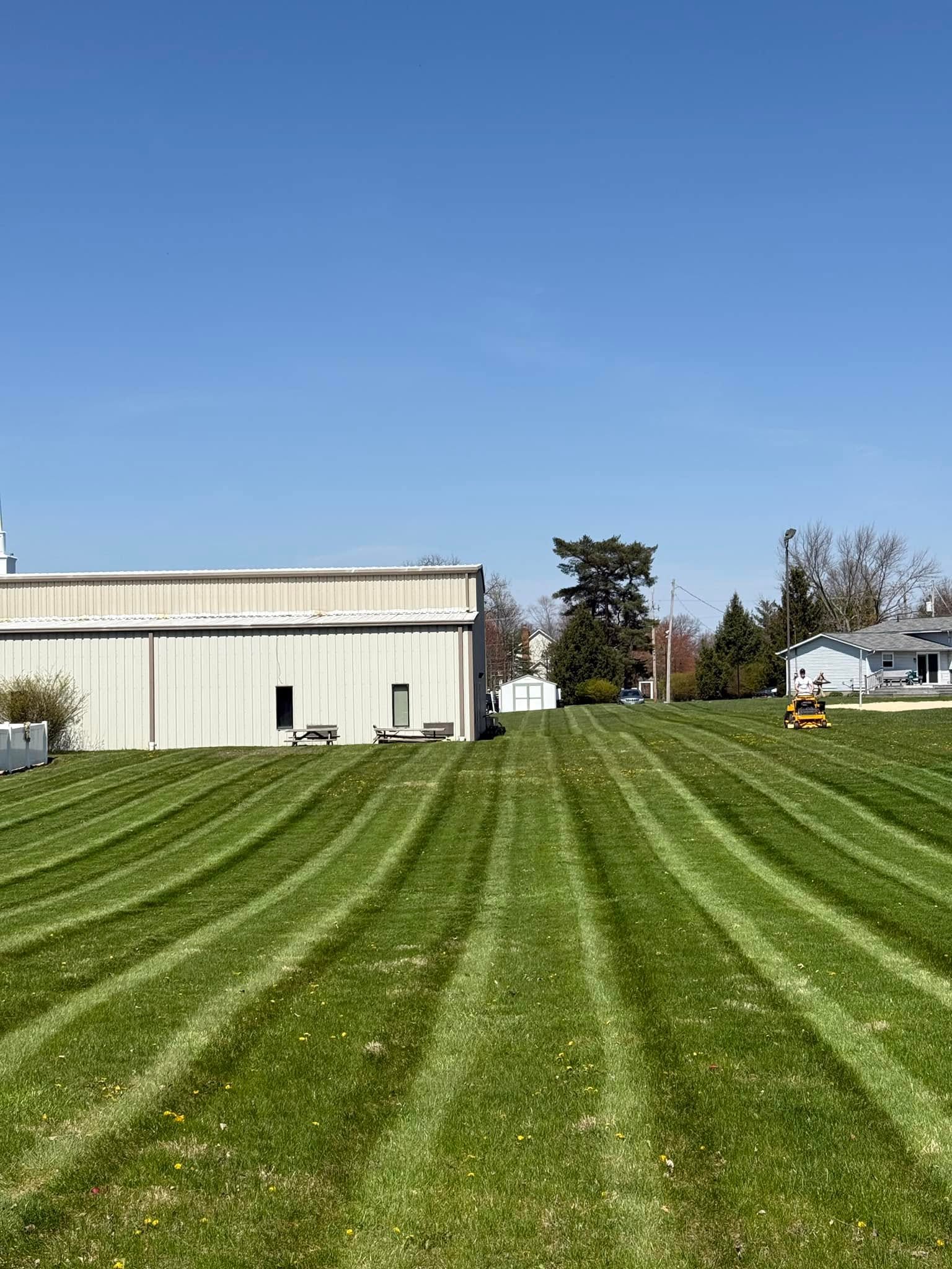 Freshly mowed lawn with crisp striping in front of a large building